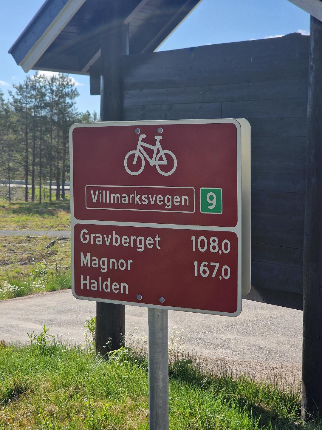 A red sign showing the distances to Gravberget, and Magnor.